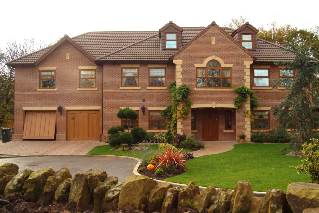 Large brick house featuring timber-style windows, doors and traditional glazing