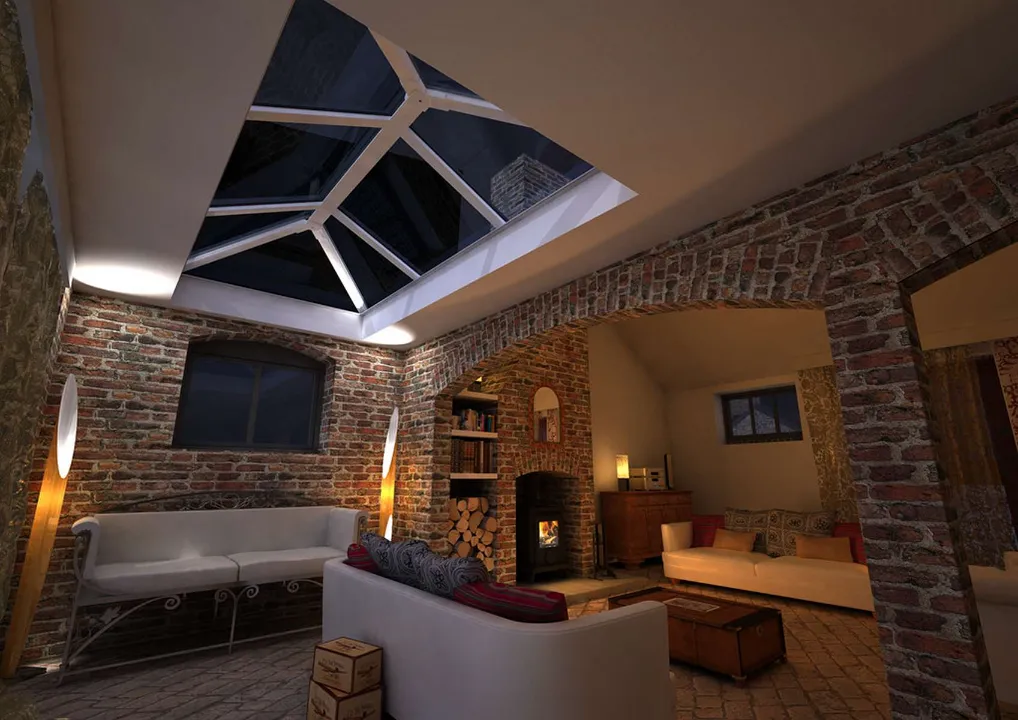 Interior living space with exposed brick walls and an open fireplace illuminated at night by a glass roof lantern set into the ceiling.